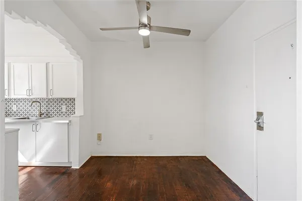 a view of an empty room with wooden floor and a cabinet