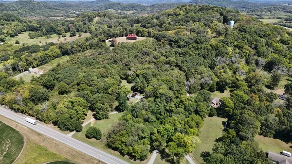an aerial view of a house with a yard and lake