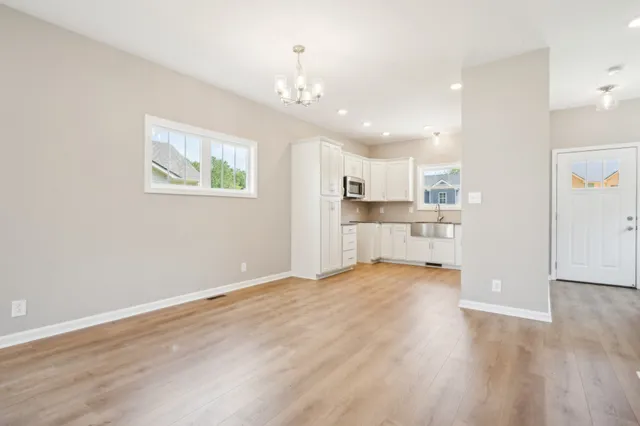 a kitchen with granite countertop white cabinets and a sink