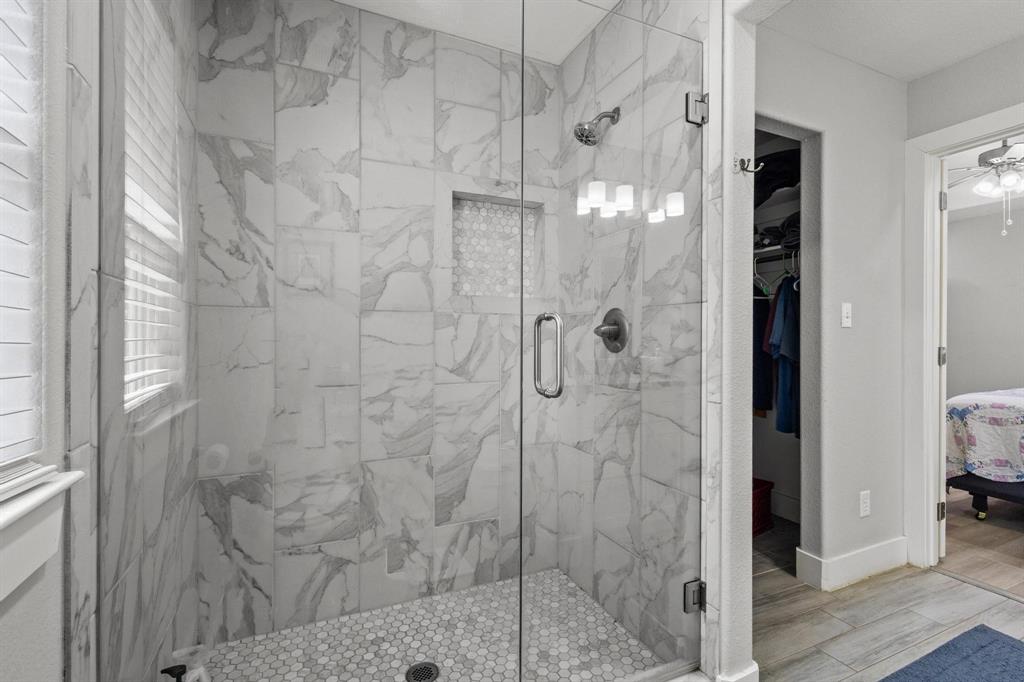 608 East Shepherd Street Denison, TX 75021 - Photo 21 of 31 Walk-in shower featuring glass enclosure, marble-style wall tile, hexagonal floor tile, recessed niche, and brushed nickel fixtures
