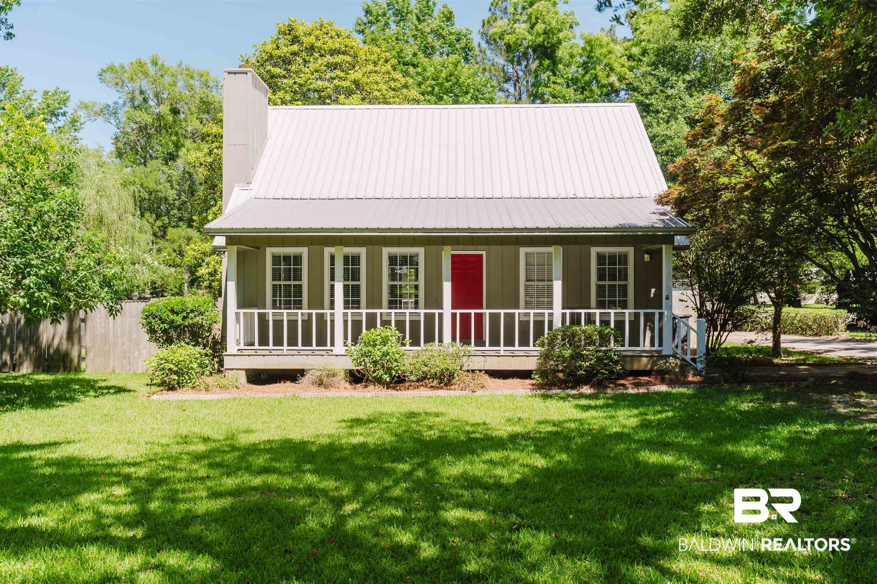 Rear view of property with a porch, a chimney, board and batten siding, and metal roof