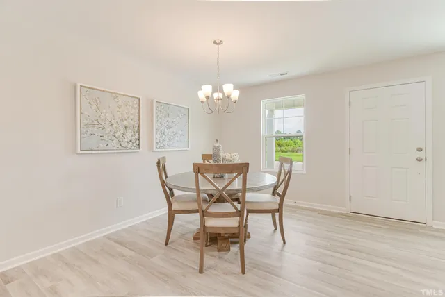 a dining room with furniture a chandelier and wooden floor