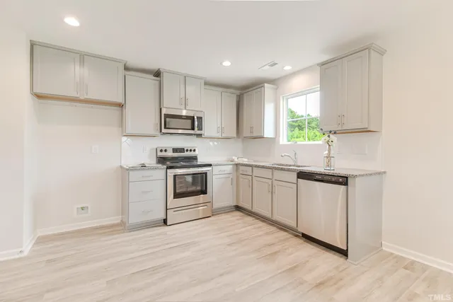 a kitchen with granite countertop white cabinets and white appliances