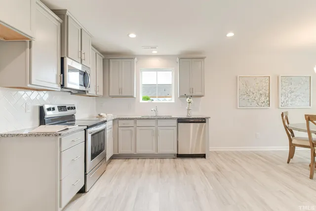 a kitchen with granite countertop white cabinets and white appliances
