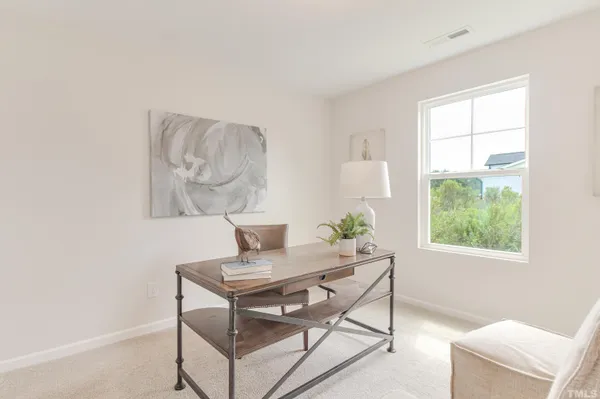 a workspace room with furniture and a window