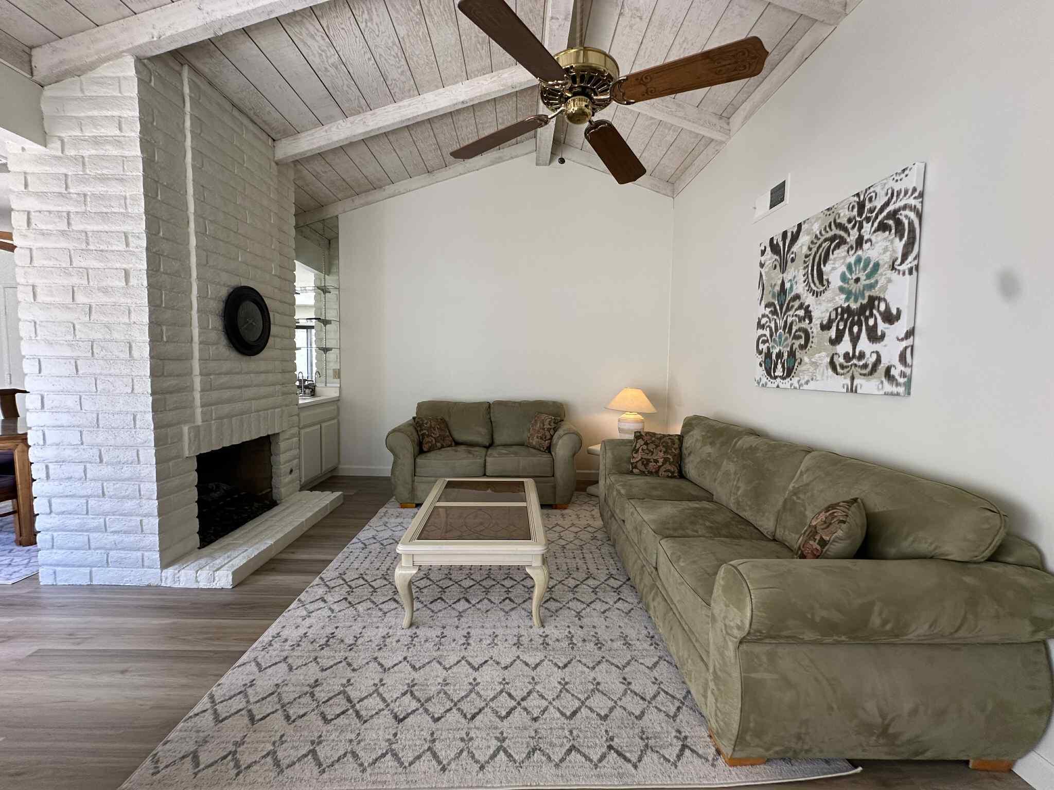 2350 East Miramonte Circle, Unit E Palm Springs, CA 92264 - Photo 14 of 35 a living room with furniture and a fireplace