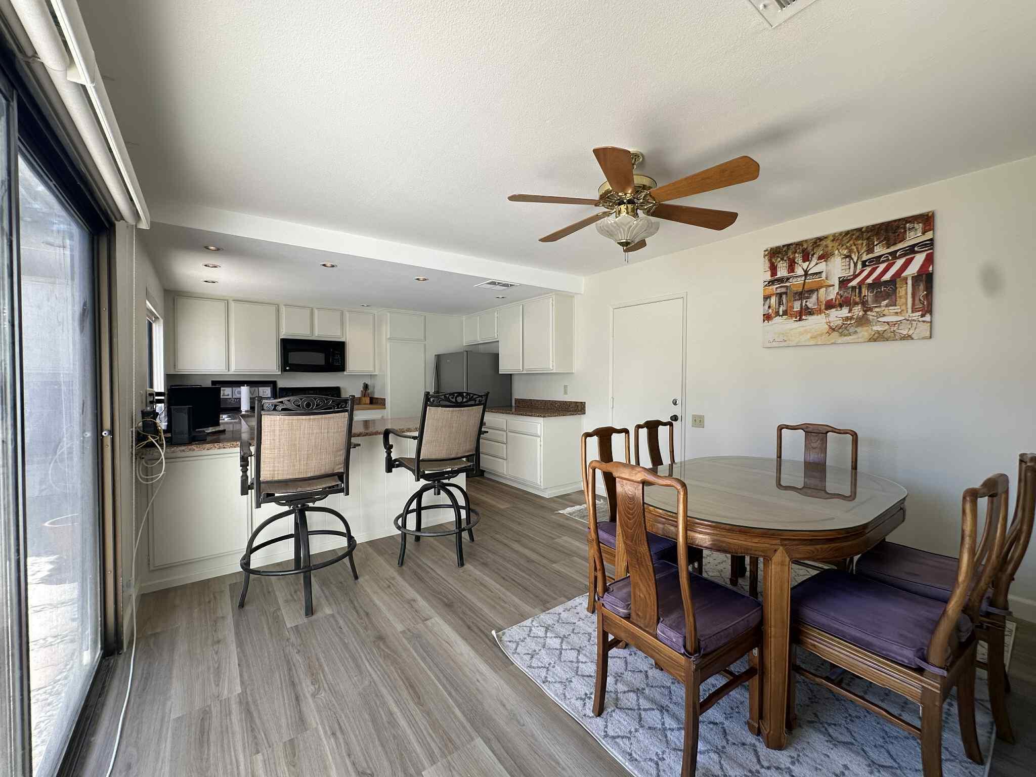 2350 East Miramonte Circle, Unit E Palm Springs, CA 92264 - Photo 19 of 35 a view of a livingroom with furniture and a dining table with wooden floor