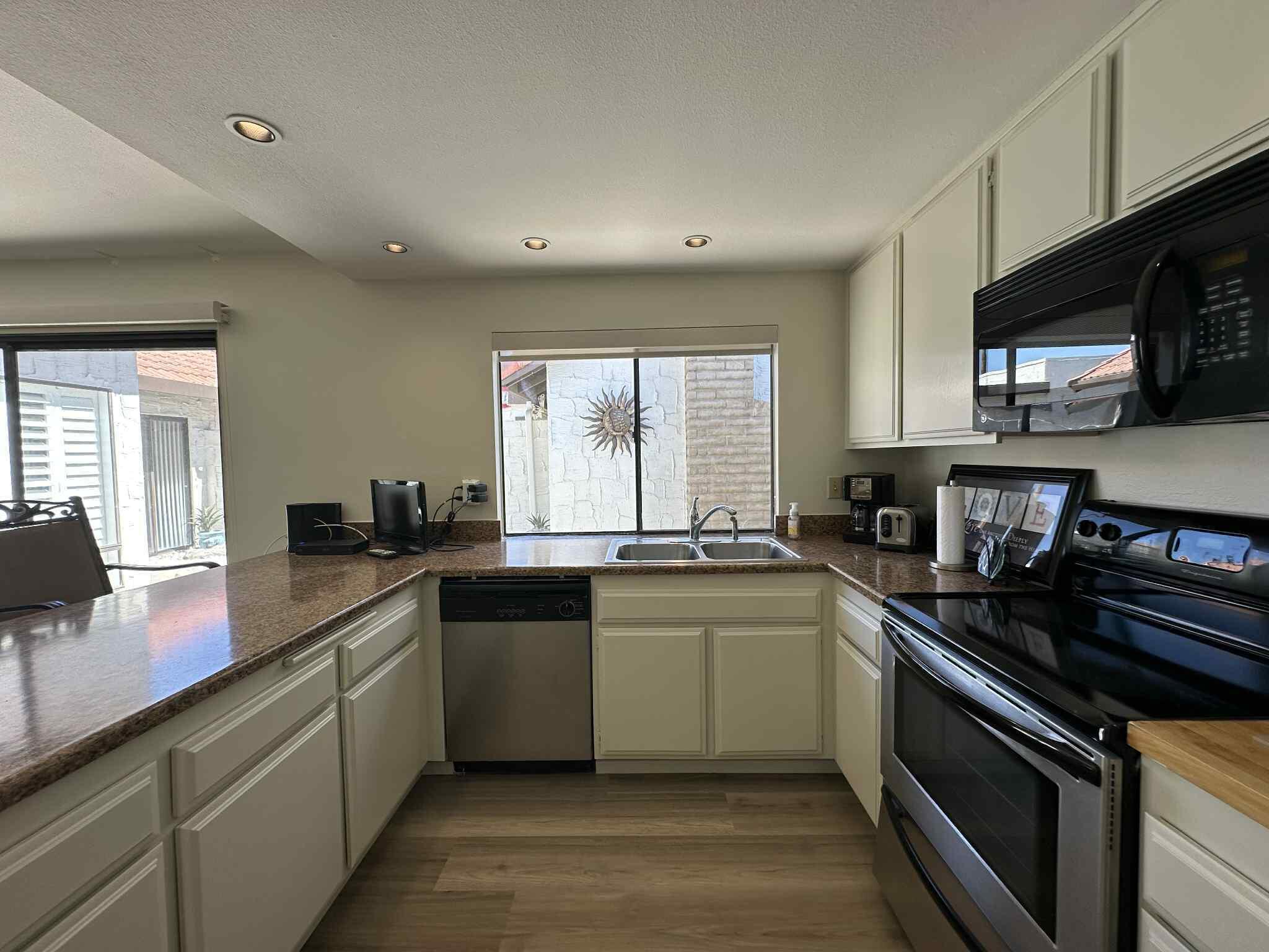 2350 East Miramonte Circle, Unit E Palm Springs, CA 92264 - Photo 22 of 35 a kitchen with a sink stove top oven and microwave