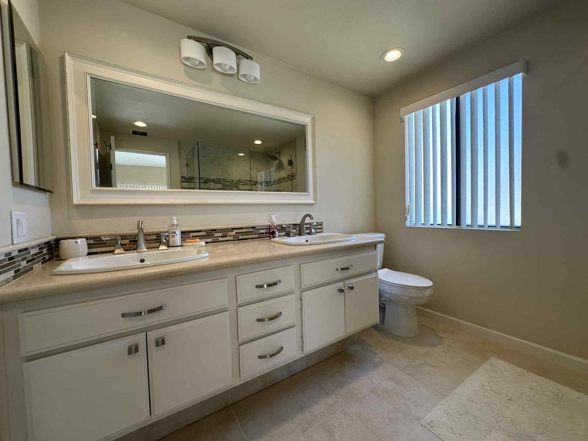 2350 East Miramonte Circle, Unit E Palm Springs, CA 92264 - Photo 27 of 35 a bathroom with double sink and a mirror