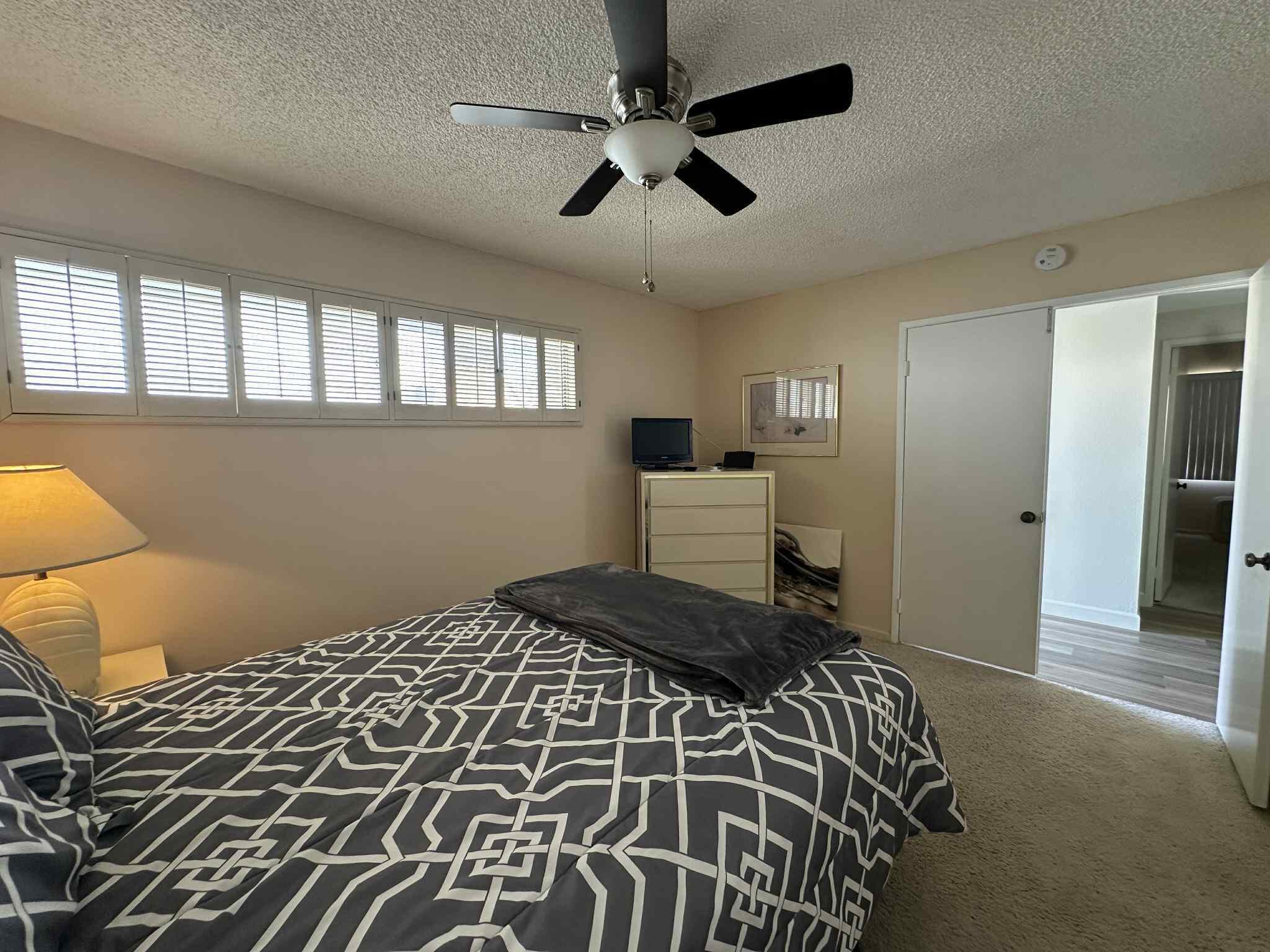 2350 East Miramonte Circle, Unit E Palm Springs, CA 92264 - Photo 29 of 35 a bedroom with a bed and a chandelier