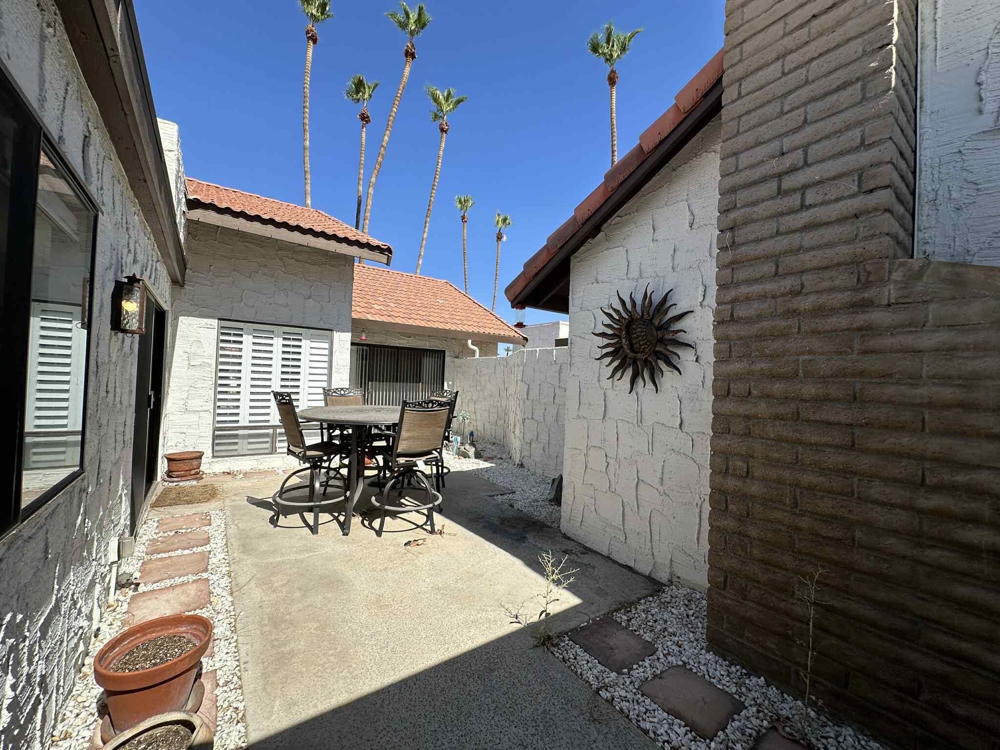 2350 East Miramonte Circle, Unit E Palm Springs, CA 92264 - Photo 33 of 35 a dining room with furniture and a potted plant