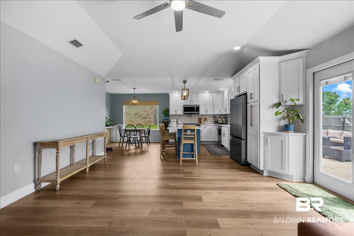8952 Sherman Road Foley, AL 36535 - Photo 13 of 41 Spacious open-concept living area featuring wood-finish flooring, vaulted ceilings, and a ceiling fan with integrated lighting