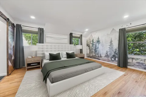 a bedroom with a large bed and a wooden floor