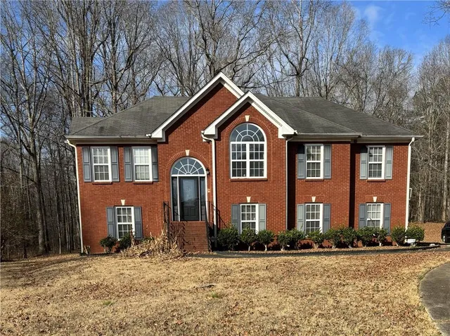 a front view of a house with yard and trees