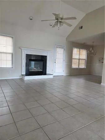 an empty room with windows and fireplace