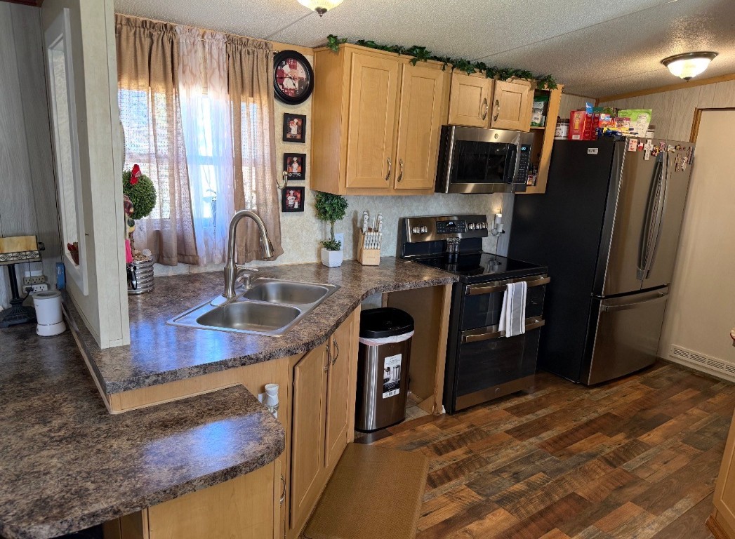 18504 Noyce Road Crosby, TX 77532 - Photo 12 of 24 a kitchen with stainless steel appliances granite countertop a sink stove and refrigerator