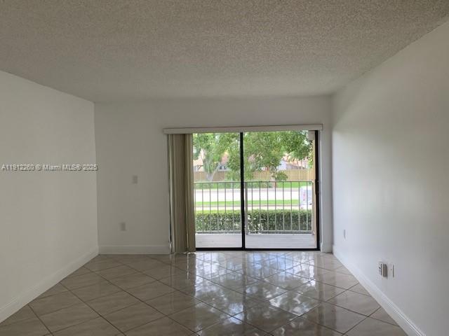 15630 Southwest 80th Street, Unit I209 Miami, FL 33193 - Photo 4 of 19 a view of an empty room with wooden floor and a window