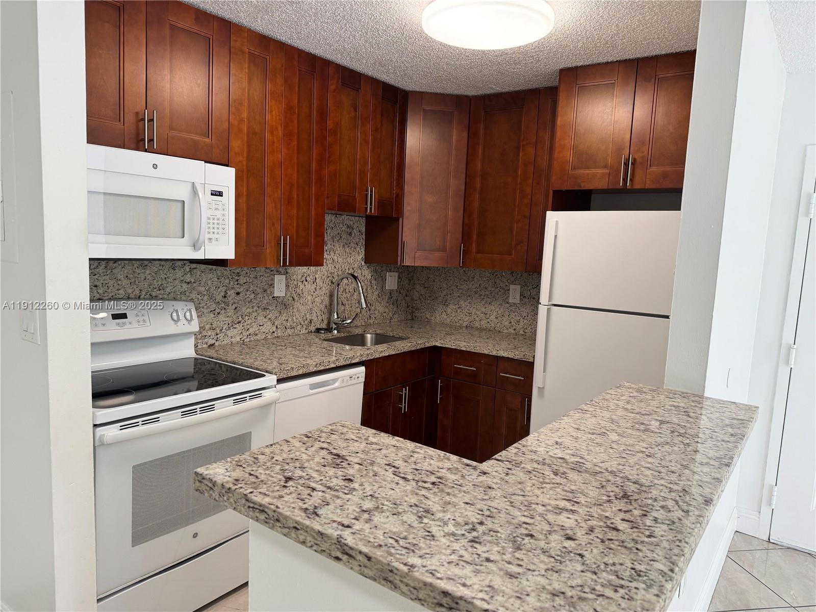 15630 Southwest 80th Street, Unit I209 Miami, FL 33193 - Photo 6 of 19 a kitchen with a refrigerator and a sink