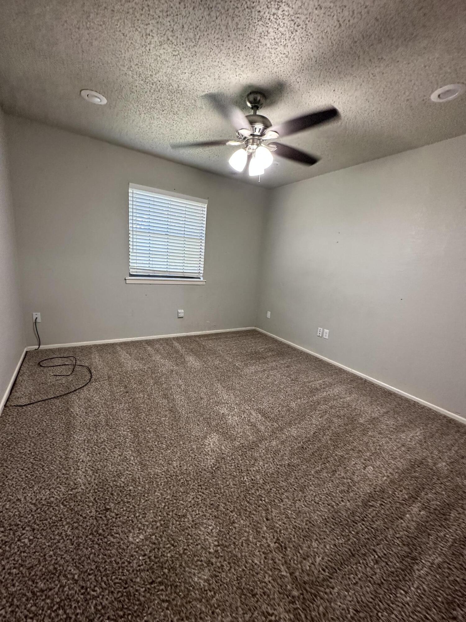 4804 71st Street Lubbock, TX 79424 - Photo 14 of 14 an empty room with windows and fan
