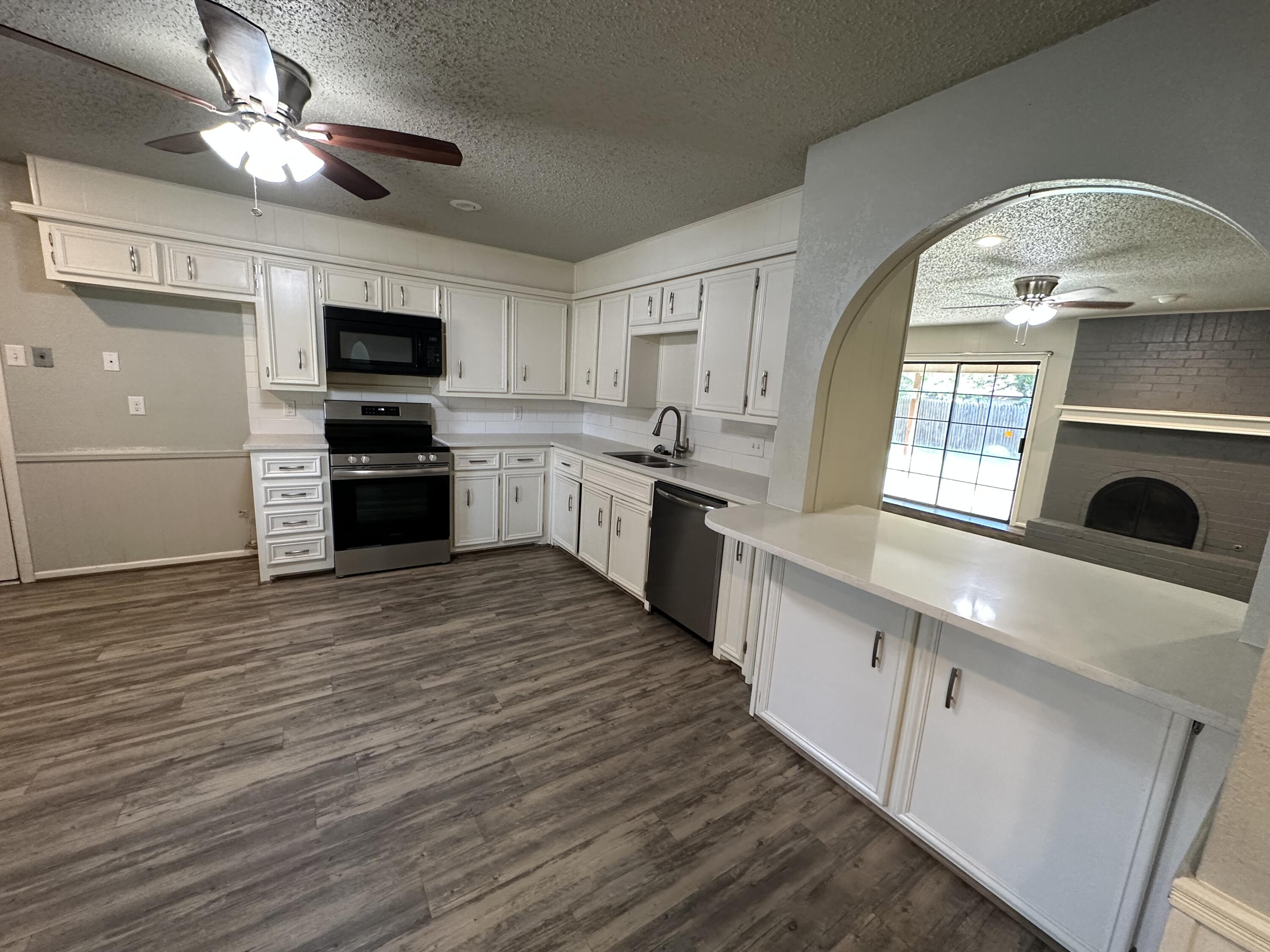 4804 71st Street Lubbock, TX 79424 - Photo 3 of 14 a large kitchen with stainless steel appliances granite countertop a stove and a sink