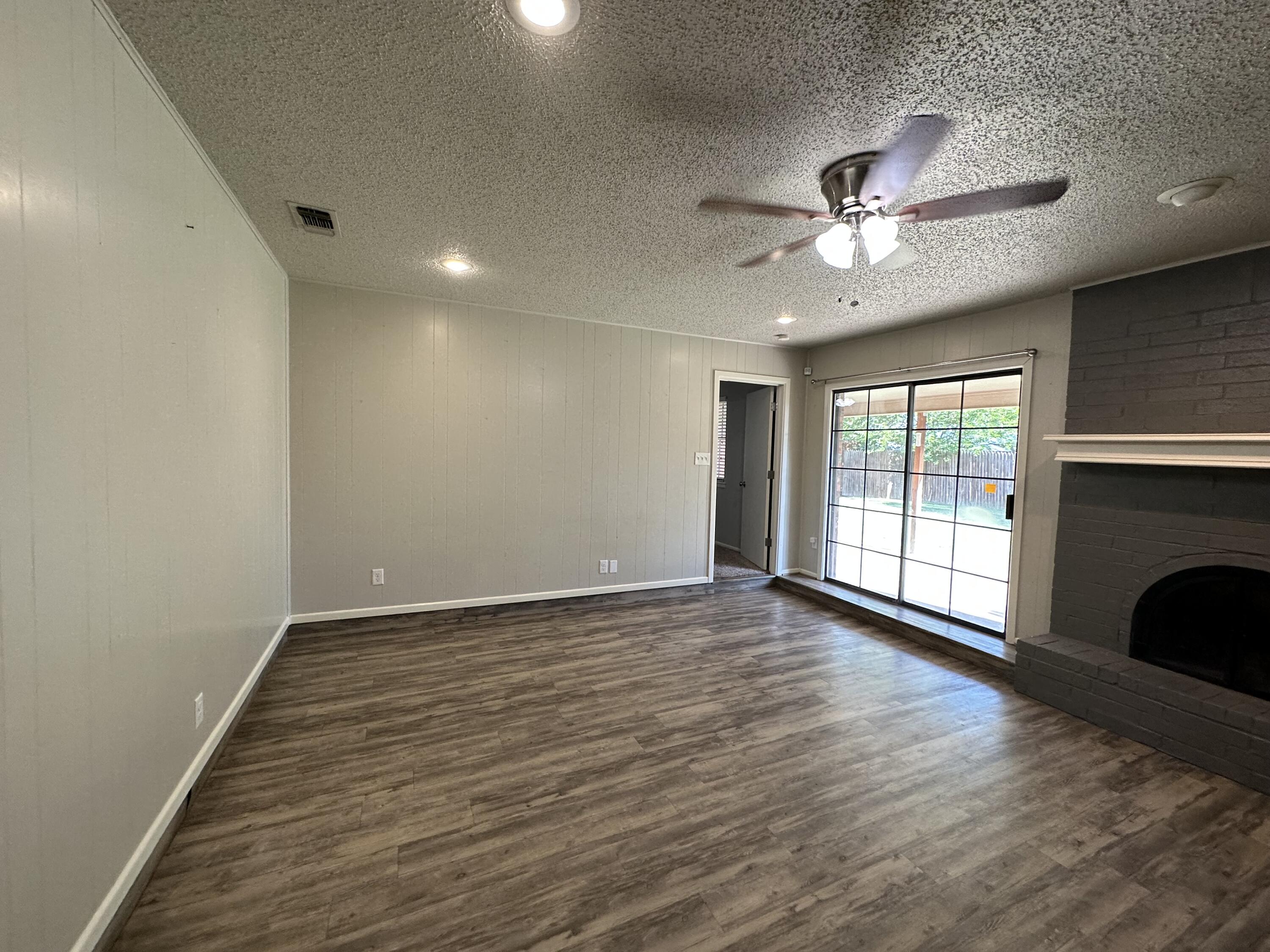4804 71st Street Lubbock, TX 79424 - Photo 6 of 14 a view of an empty room with a window and wooden floor