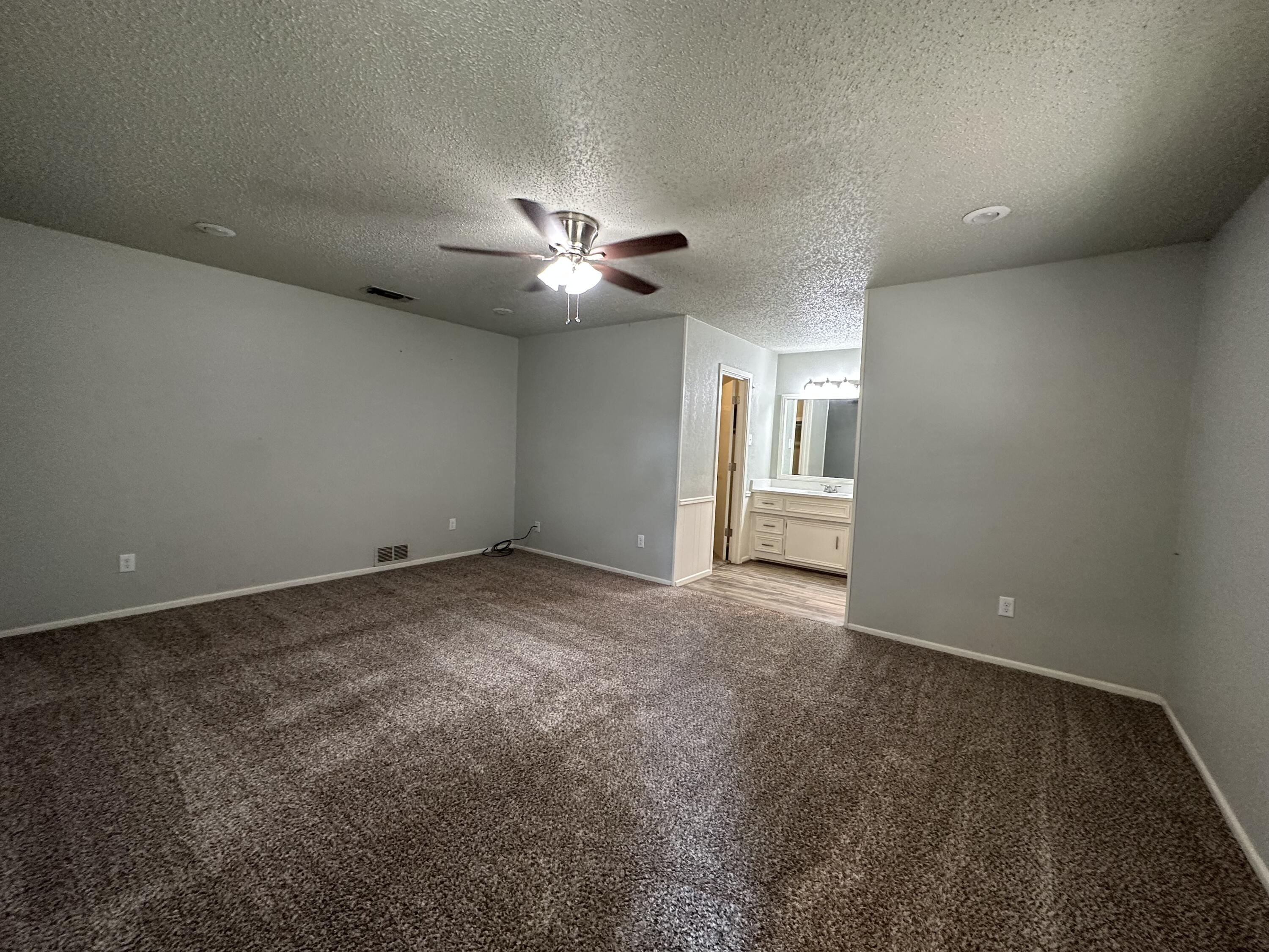 4804 71st Street Lubbock, TX 79424 - Photo 7 of 14 a view of an empty room with a chandelier fan