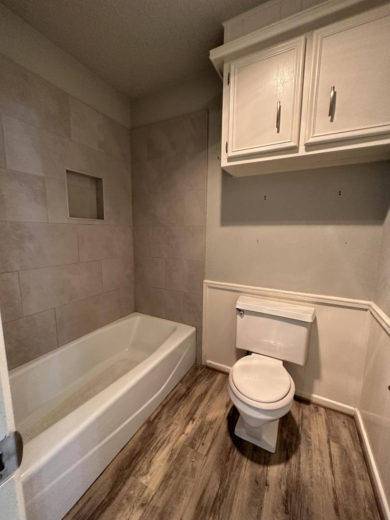 4804 71st Street Lubbock, TX 79424 - Photo 9 of 14 a bathroom with a toilet a sink and a bathtub