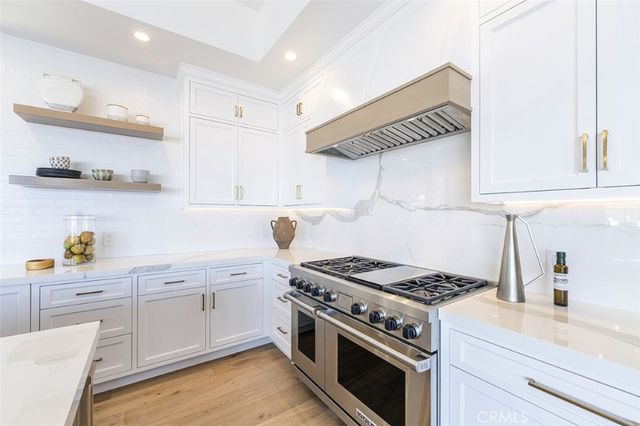 a kitchen with granite countertop a sink cabinets and stainless steel appliances