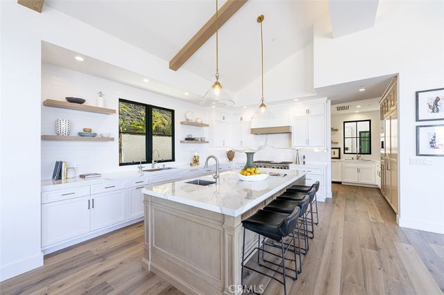 a kitchen with a sink a counter space appliances and cabinets