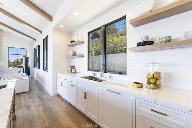 a kitchen with a sink cabinets and wooden floor