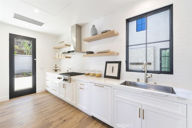 a kitchen with a sink cabinets and wooden floor