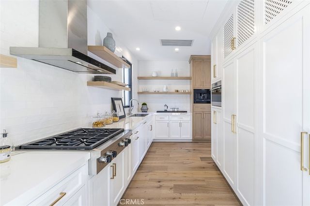 a kitchen with white cabinets and appliances