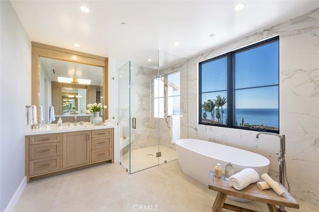 a spacious bathroom with a tub sink and mirror