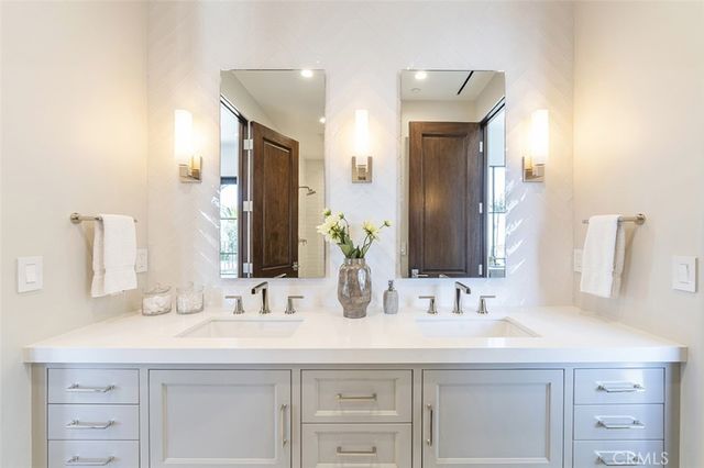 a bathroom with double vanity sinks and a mirror