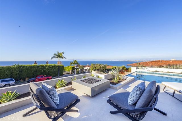 a view of swimming pool with outdoor seating lounge chairs