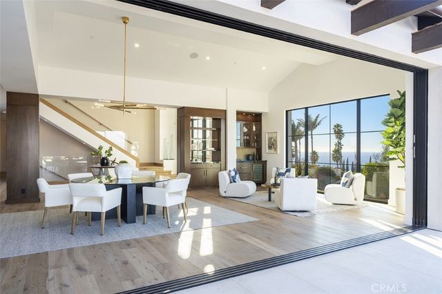 a living room with lots of table furniture and a large window