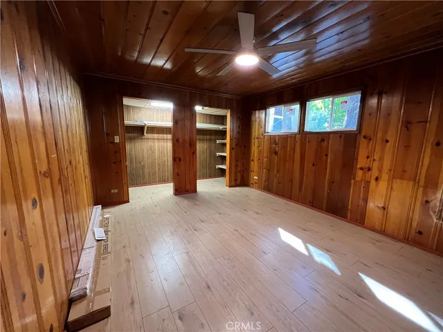 en empty room with wooden floor and windows
