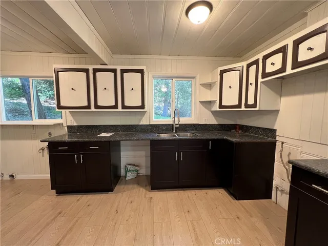 a kitchen with granite countertop a refrigerator and a sink