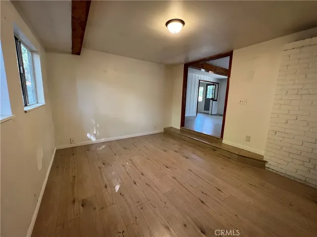 an empty room with wooden floor and entrance