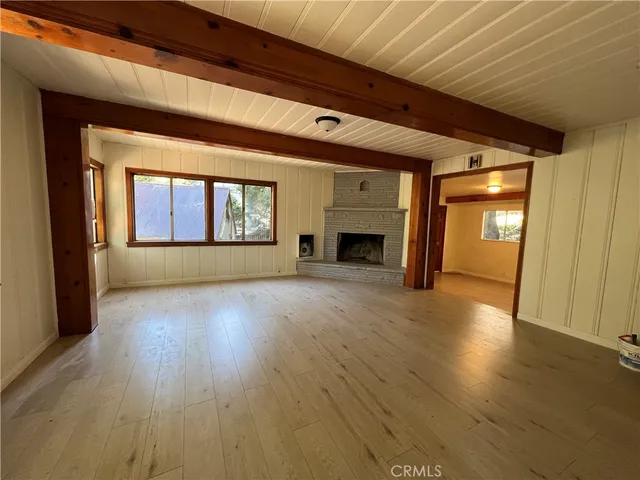 an empty room with wooden floor and a fireplace