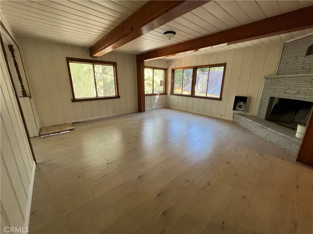 a view of an empty room with a fireplace and a window