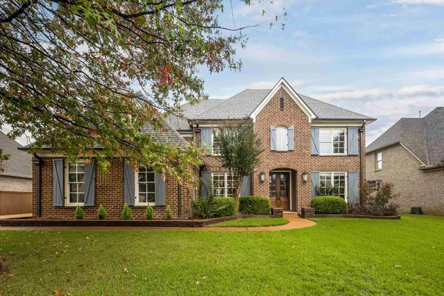 a front view of a house with a garden and plants