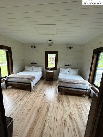 a bedroom with two beds and a large window