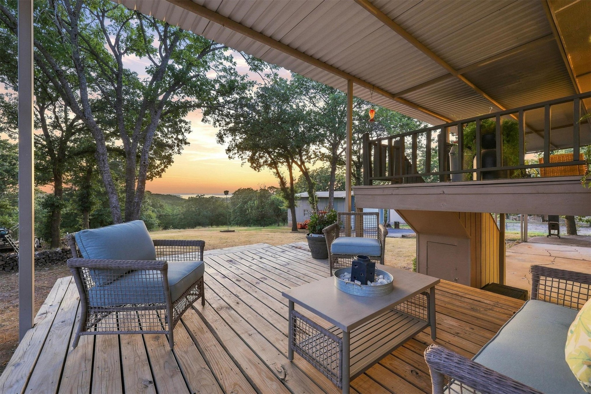 171 Woods Road Mead, OK 73449 - Photo 54 of 62 Covered wood-plank deck with a corrugated metal ceiling and an elevated wood balcony