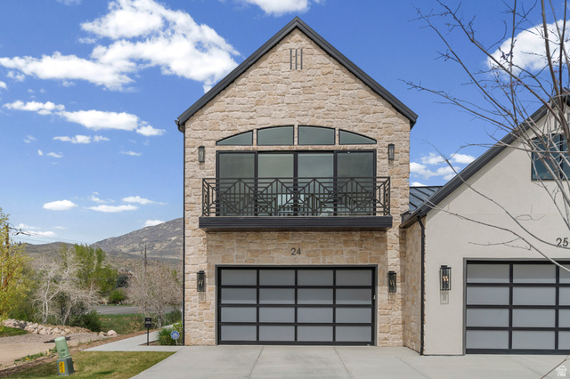 250 South Main Street, Unit 24 Alpine, UT 84004 - Photo 3 of 50 View of front of house with stone siding, concrete driveway, a balcony, an attached garage, and stucco siding