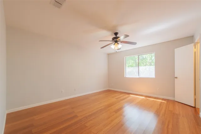 a view of a kitchen with wooden floor and a window