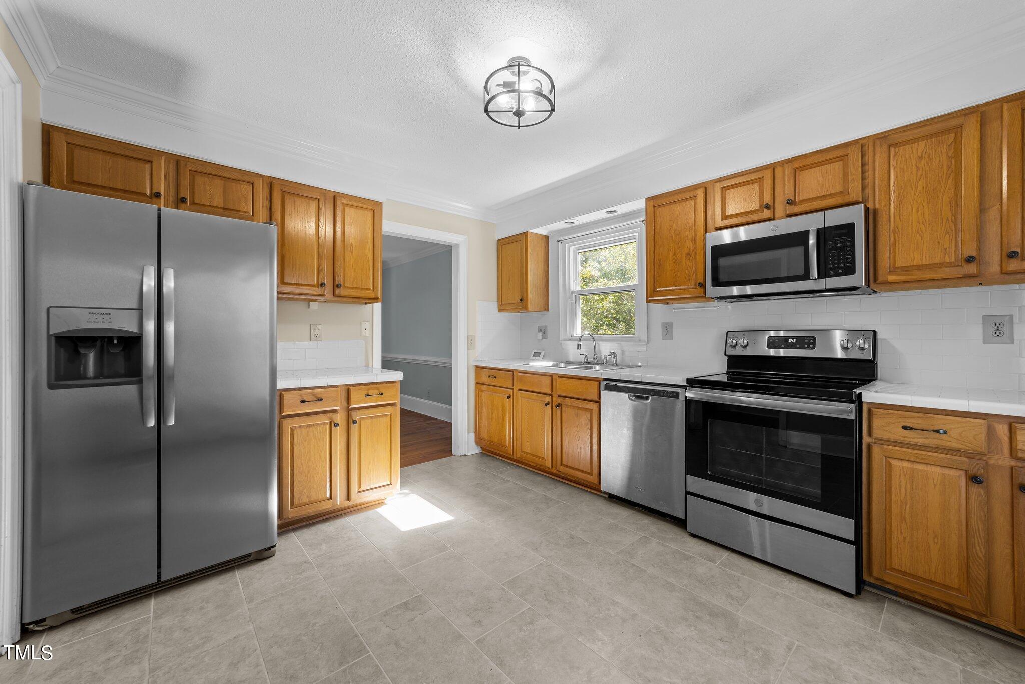 1104 Terrace Court Raleigh, NC 27615 - Photo 11 of 39 a kitchen with stainless steel appliances granite countertop a refrigerator a stove a sink and a microwave