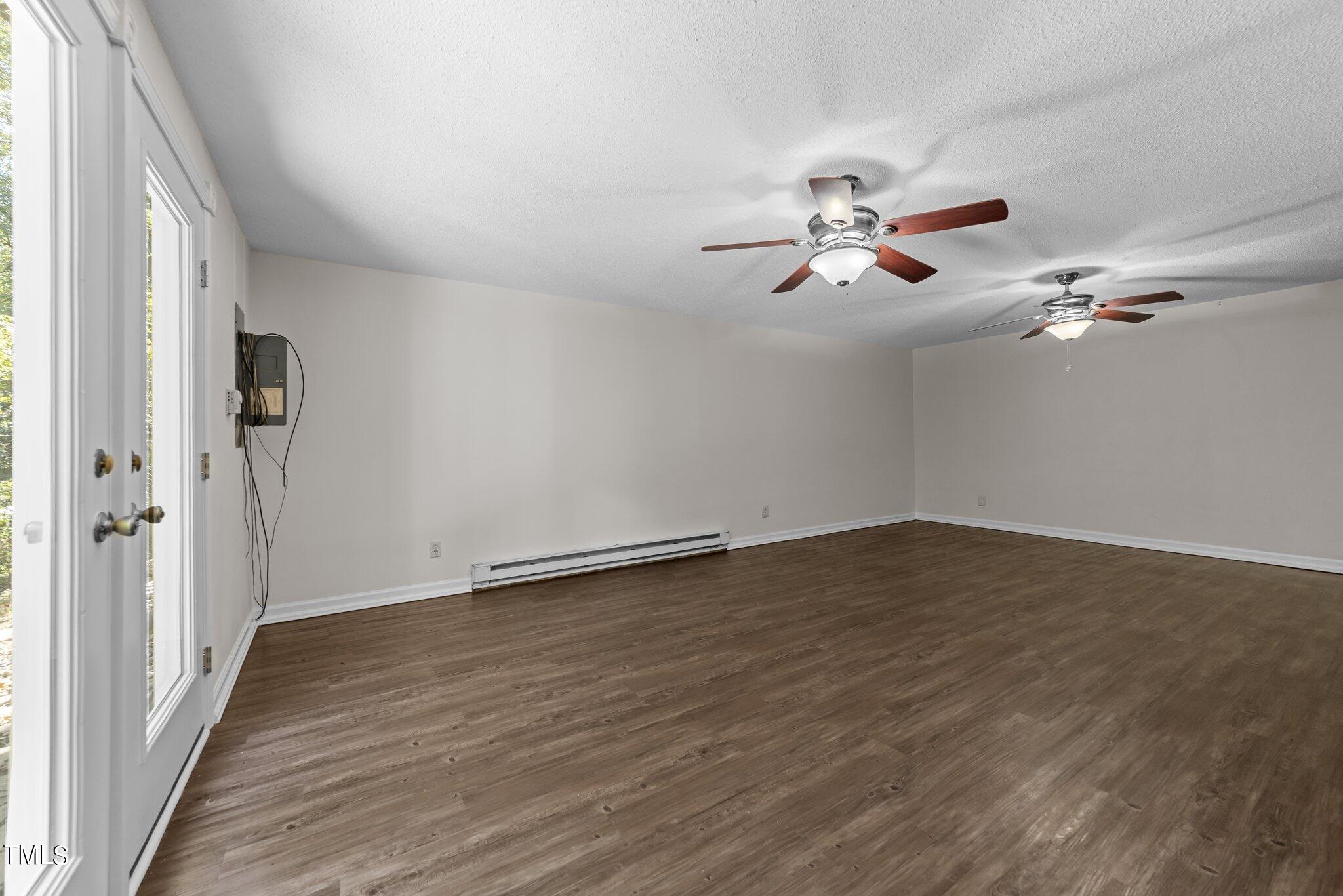 1104 Terrace Court Raleigh, NC 27615 - Photo 23 of 39 a view of an empty room with chandelier fan and wooden floor