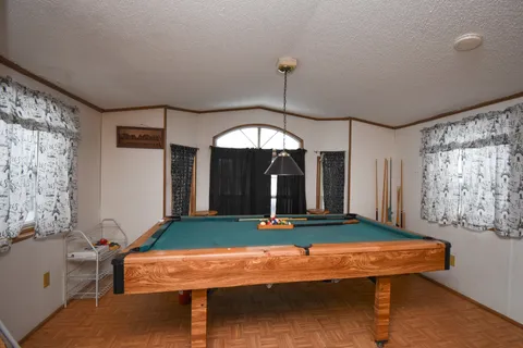 a room with pool table and windows