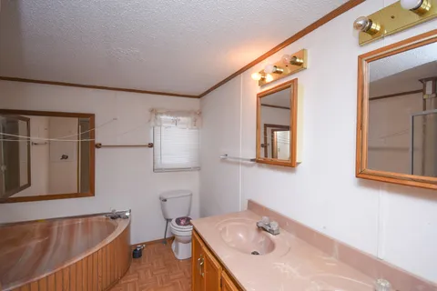 a bathroom with a tub sink and mirror